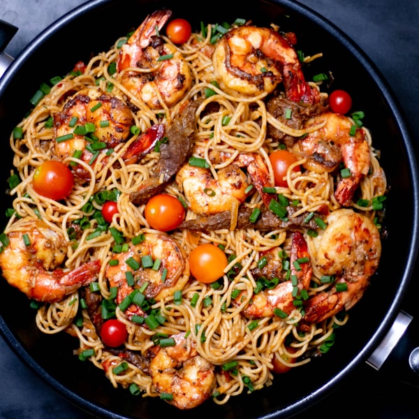 A bowl of shrimp spaghetti with tomatoes